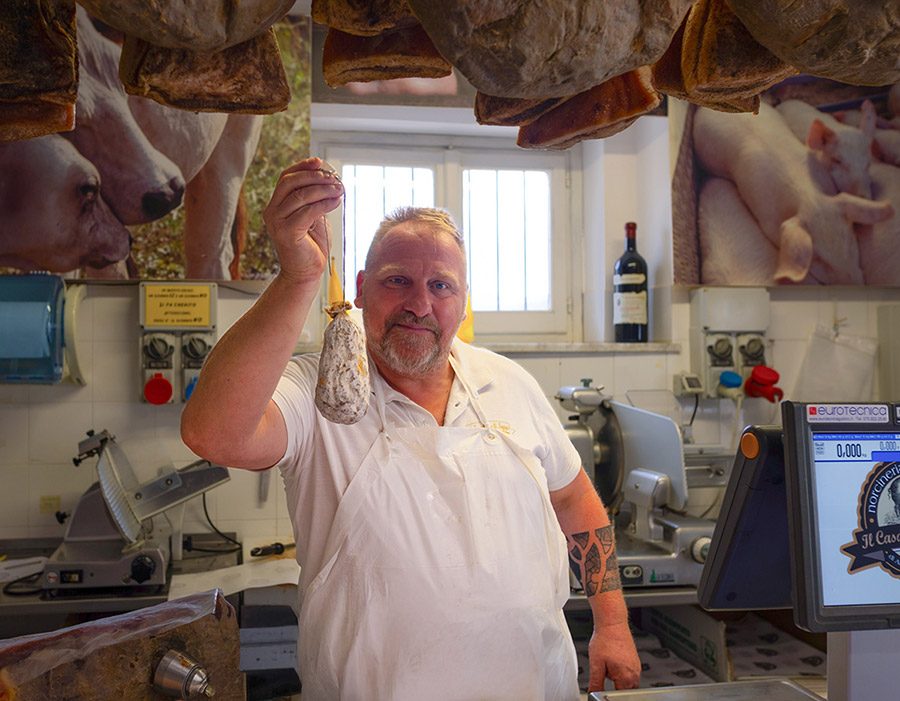 Metzger mit hausgemachter Salami im Hofladen